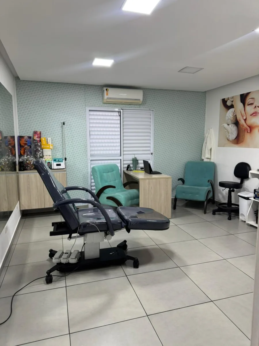 Sala de procedimentos com maca elétrica e poltronas verde-tiffany